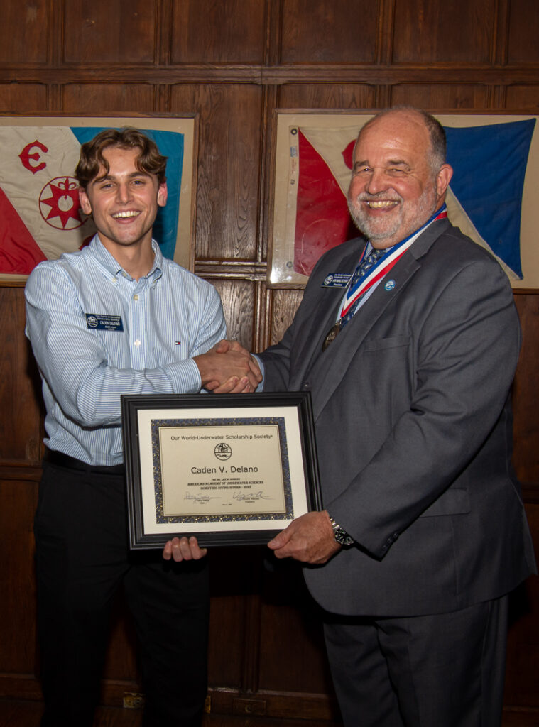 University of Florida student and Florida Museum of Natural History employee Caden Delano being congratulated by Vin Malkoski for the Our World Underwater Scholarship Society American Academy of Underwater Sciences Somer's Internship.